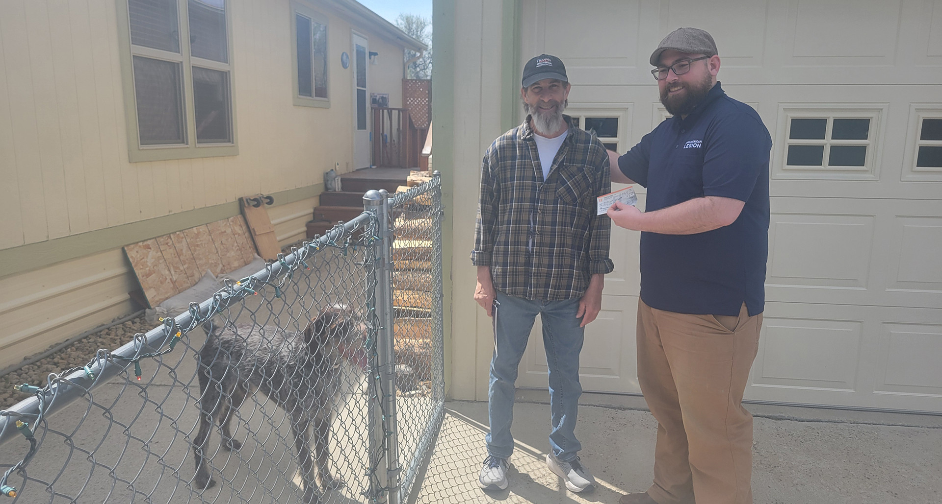 Army veteran Stephen Tichenor (middle) delivers his membership renewal to incoming Post 2 commander Joe Wagner. At left is Tichenor’s houseguest, Winston. (Photo by Laura Edwards)