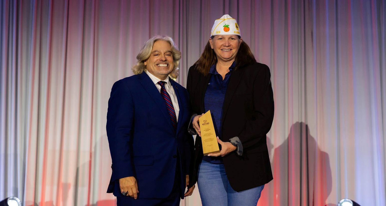 Department of Florida Commander Jessica Moore receives a Meeting the Moment award from Visit Tampa Bay President/CEO Santiago Corrada. (Photo via Visit Tampa Bay)