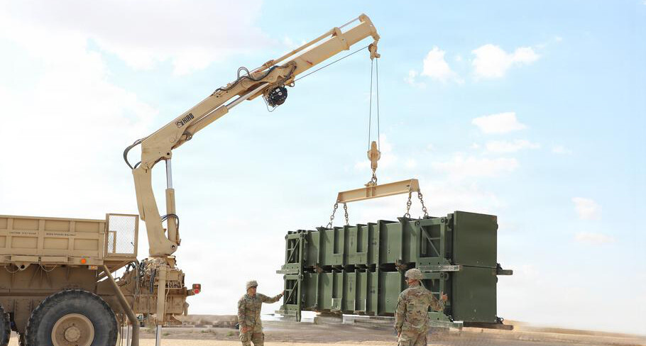 Soldiers use a crane to lift Patriot missile canisters in the Middle East. (Courtesy of U.S. Army)