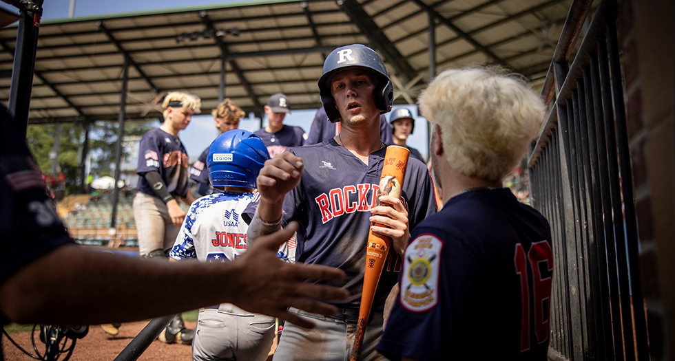 Braden Pruitt of Rockport, IN Post 254 is congratulated by his teammates after scoring a run during Game 01 of the 2025 American Legion World Series. Photo by Chet Strange