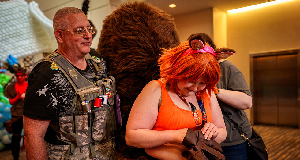 “Costume Corpsman” Vic Mitchell helps fix the tail of an attendee cosplaying during Gen Con 2025 at the Indiana Convention Center. (Photo by Jennifer Blohm/The American Legion)