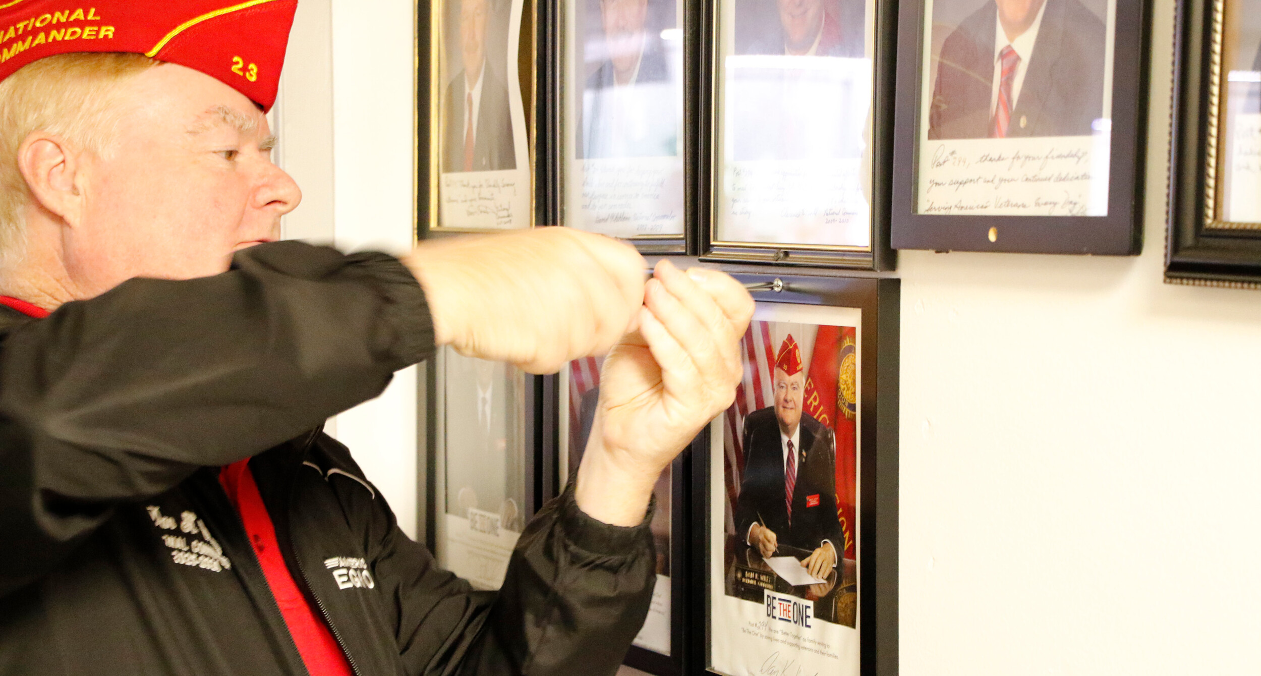 Commander Wiley adds his official portrait to the wall at Wilbur M. Comeau Post 4.