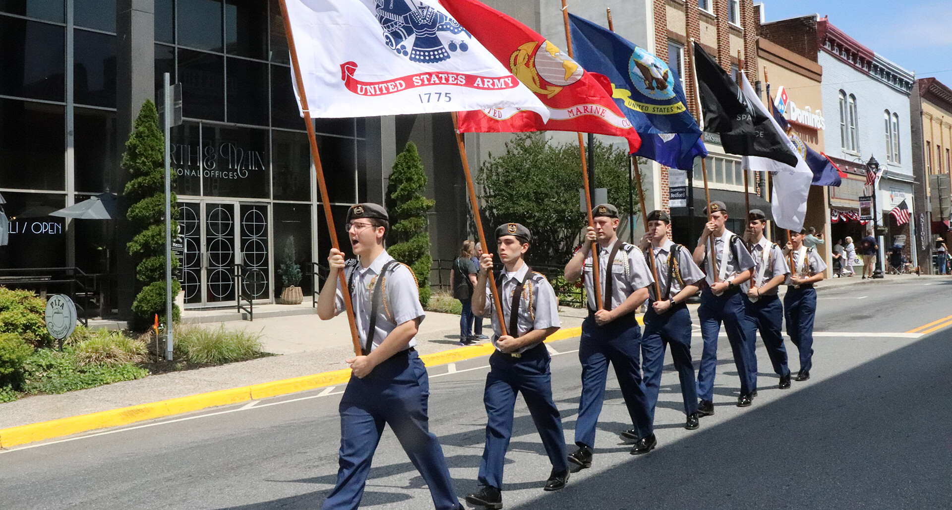 Cadets of the Bedford County Public Schools Army JROTC unit, “Wolfpack Battalion,” carry flags of the six U.S. service branches in a Bedford, Va., parade May 16. Photo by Sue Moore