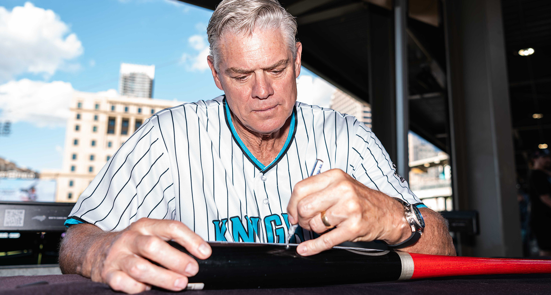 Former major leaguer Dale Murphy signs a bat during an appearance at a Charlotte Knights game. Photo by Laura Wolff/Charlotte Knights.