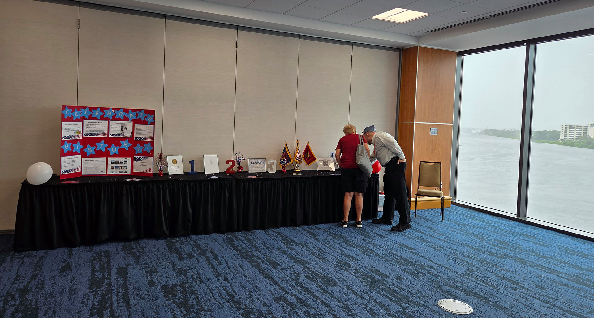American Legion Library and Museum Division Director Howard Trace (right) guides a visitor through the histories on display at the Tampa Convention Center. (Photo by Laura Edwards)