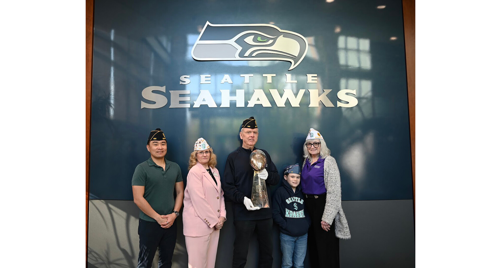 Mike Flood (center) holds the Lombardi Trophy alongside fellow Legion Family members at Seahawks headquarters in Renton, Wash., in April. (Photo via Alyson Teeter)