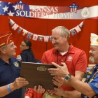 American Legion National Commander Charles E. Schmidt and Kansas Department Commander Terry Marr present Kansas Soldiers' Home Superintendent David Smith with a plaque and OCW donation on Friday, August 11, 2017. Photo by Clay Lomneth / The American Legion. 